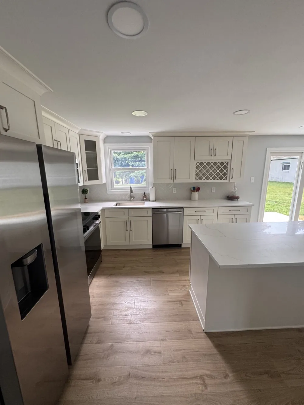 Cream cabinets with a white island and wood-look floors.