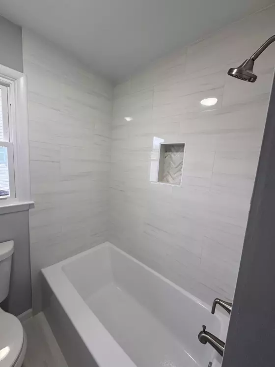 Full-height tile tub surround with brushed-nickel shower trim