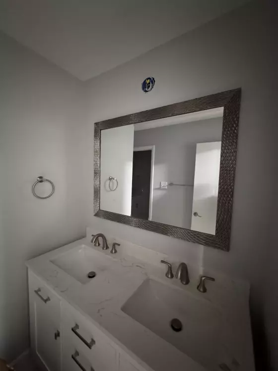 Double vanity and framed mirror with brushed-nickel faucets