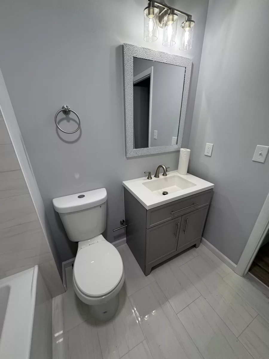 Gray shaker vanity, framed mirror and brushed-nickel fixtures