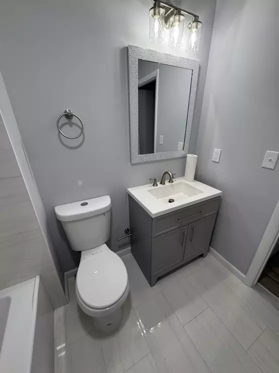 Gray shaker vanity, framed mirror and brushed-nickel fixtures