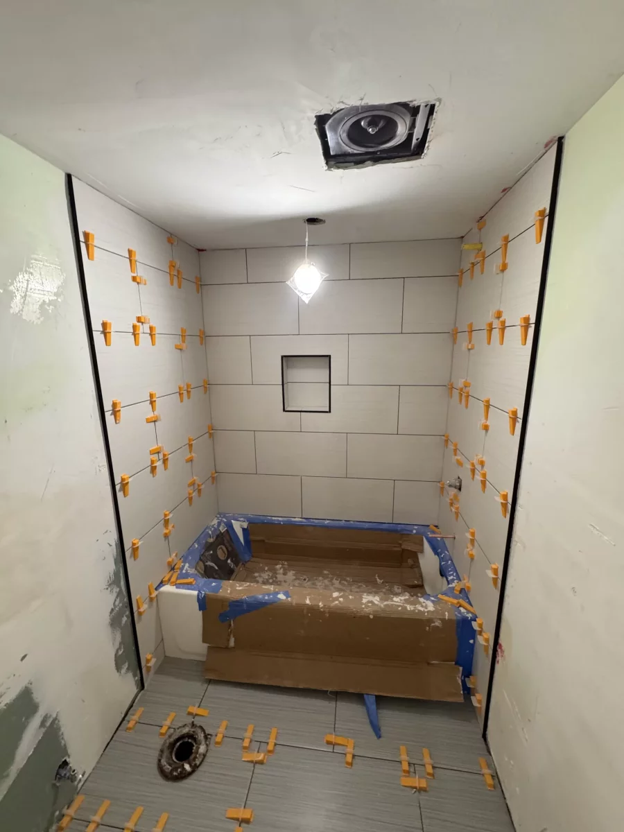 Large-format wall tile with a recessed niche around a protected tub