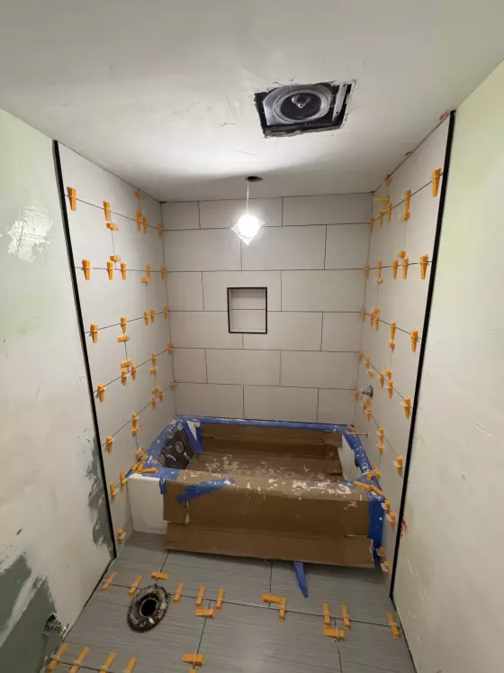 Large-format wall tile with a recessed niche around a protected tub