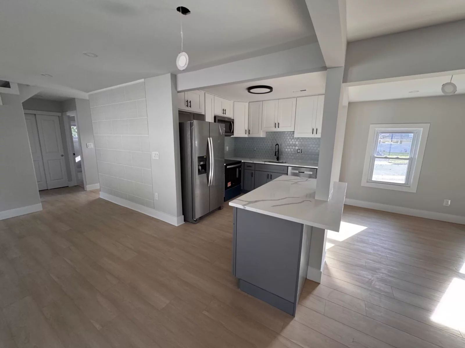 Open floor plan with the new kitchen, island and wood-look plank flooring