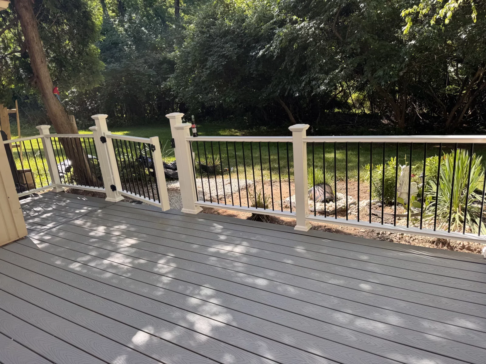 Gray composite deck looking out over a wooded backyard