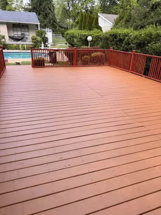 Rebuilt wood deck with new boards and stained red-brown railing in Jenkintown, PA