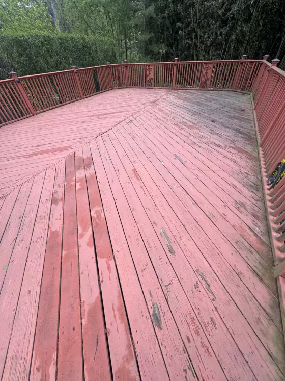 Old deck with worn, faded red paint before the rebuild