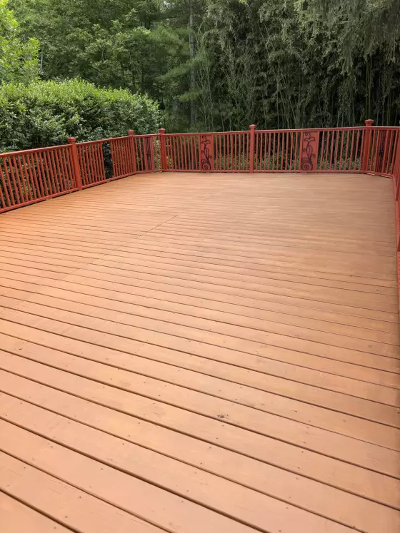 New deck boards stained red-brown, seen from the same corner