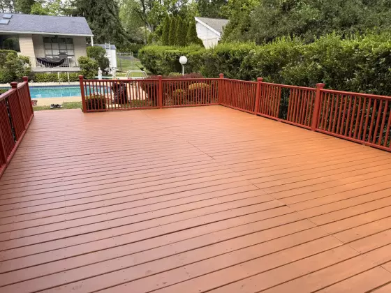 Finished deck with new boards and railing overlooking the yard
