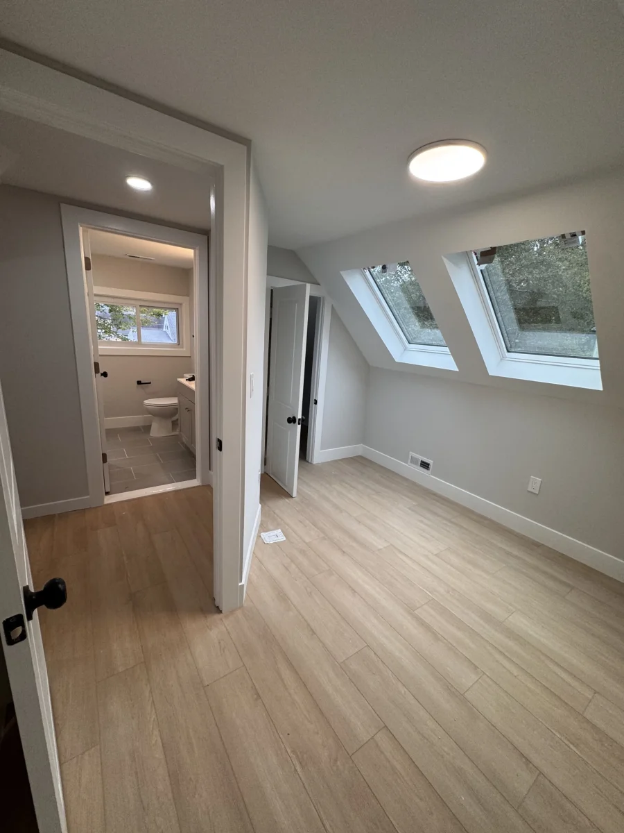 Upstairs bedroom with two skylights, recessed lighting and light wood-look flooring in Levittown