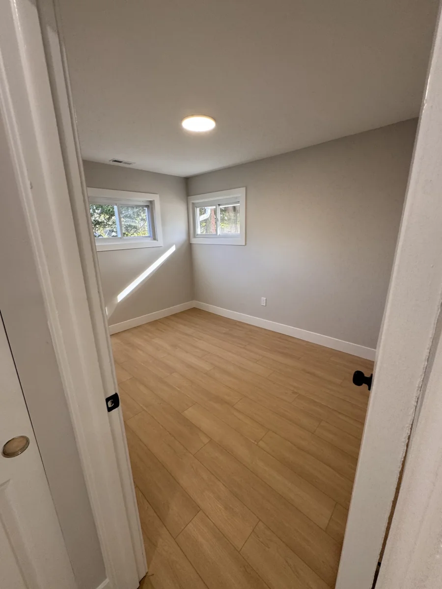Bedroom with two windows and light wood-look flooring