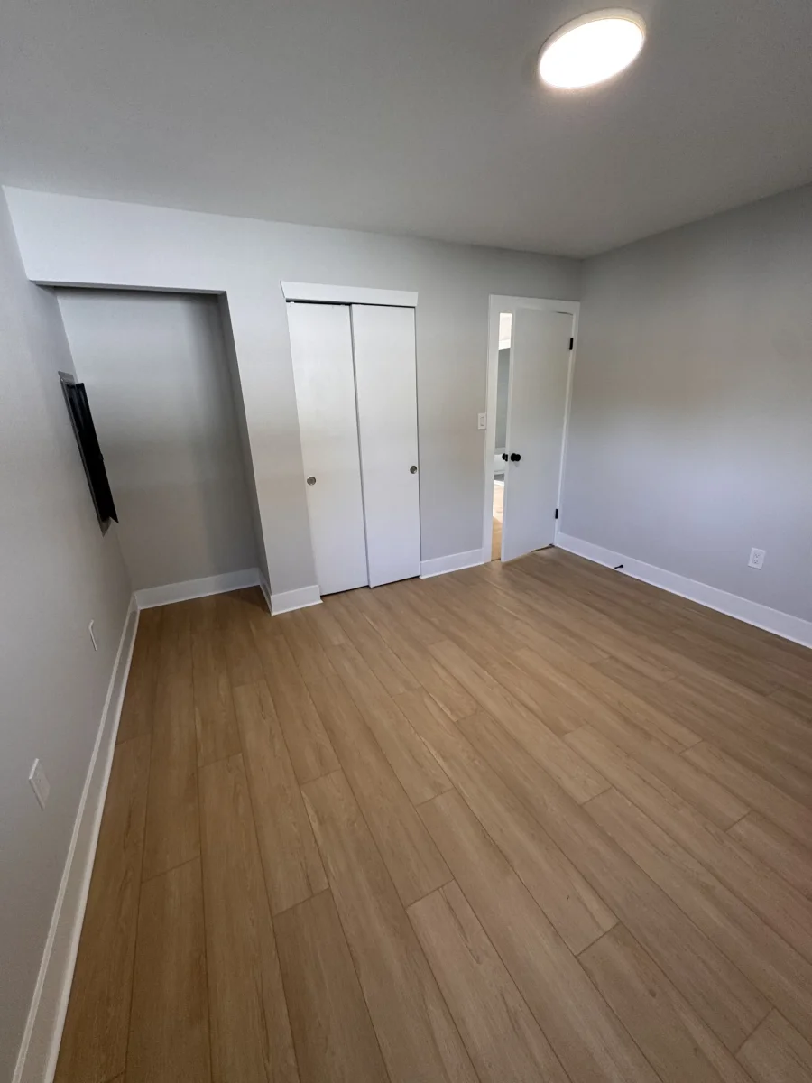 Bedroom with white closet doors and wood-look flooring