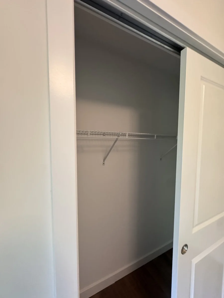 Reach-in closet with a wire shelf and white sliding door
