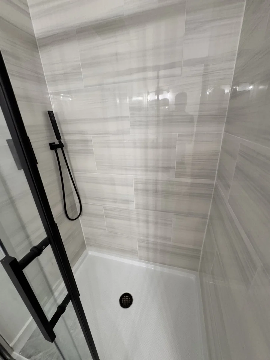 Hand shower and rain head on stone-look tile