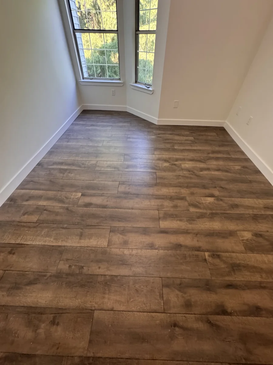 Bedroom with dark wood-look flooring and fresh white paint in Newtown