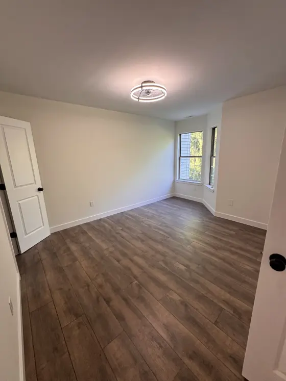 Bedroom with a ceiling light and dark wood-look flooring